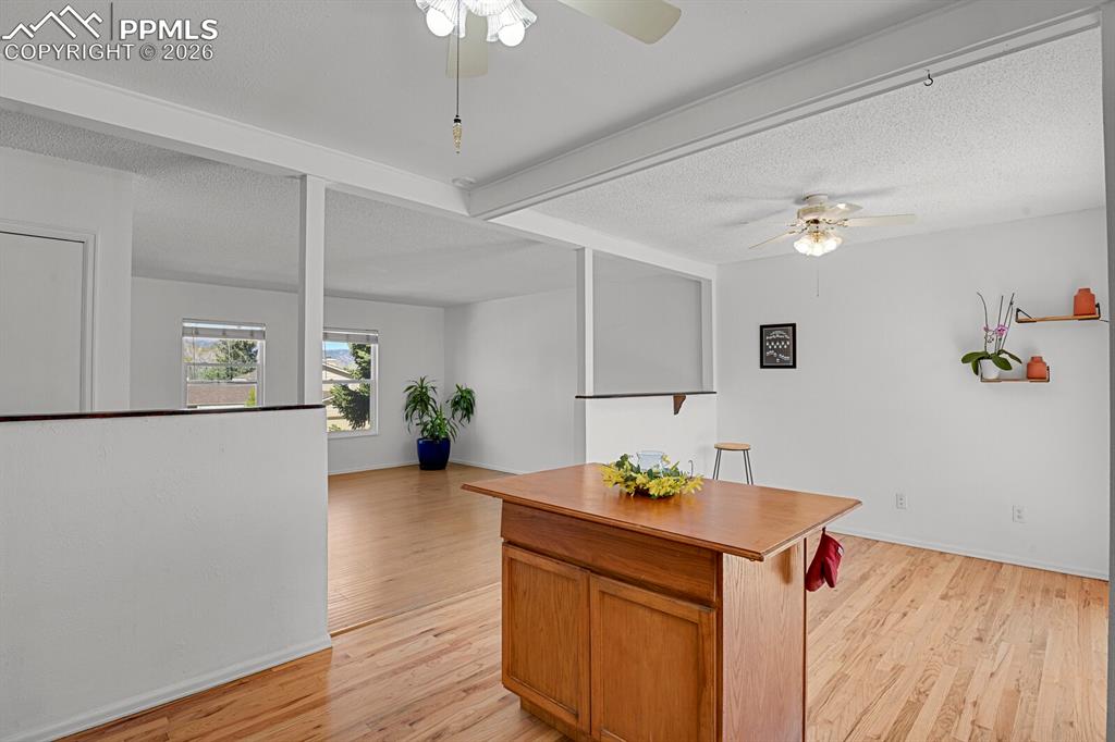 Image 8 of 30: This bright interior features hardwood flooring, white walls, and a ceiling