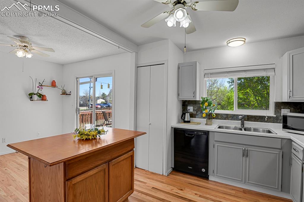 Image 9 of 30: Kitchen and dining area featuring hardwood flooring, an island with a woode