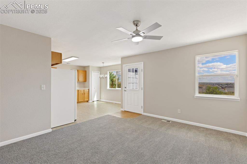Image 16 of 50: The living room leads into the kitchen with access to the back yard