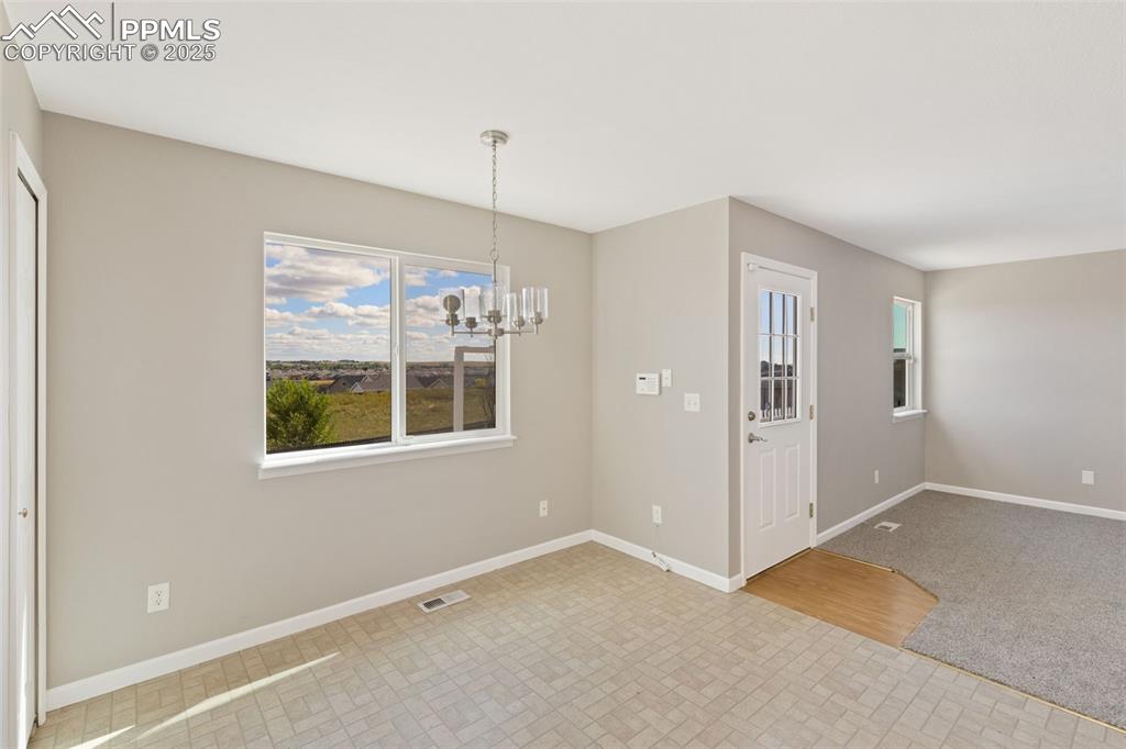 Image 27 of 50: Dining area in the kitchen over -ooks the back yard and open space