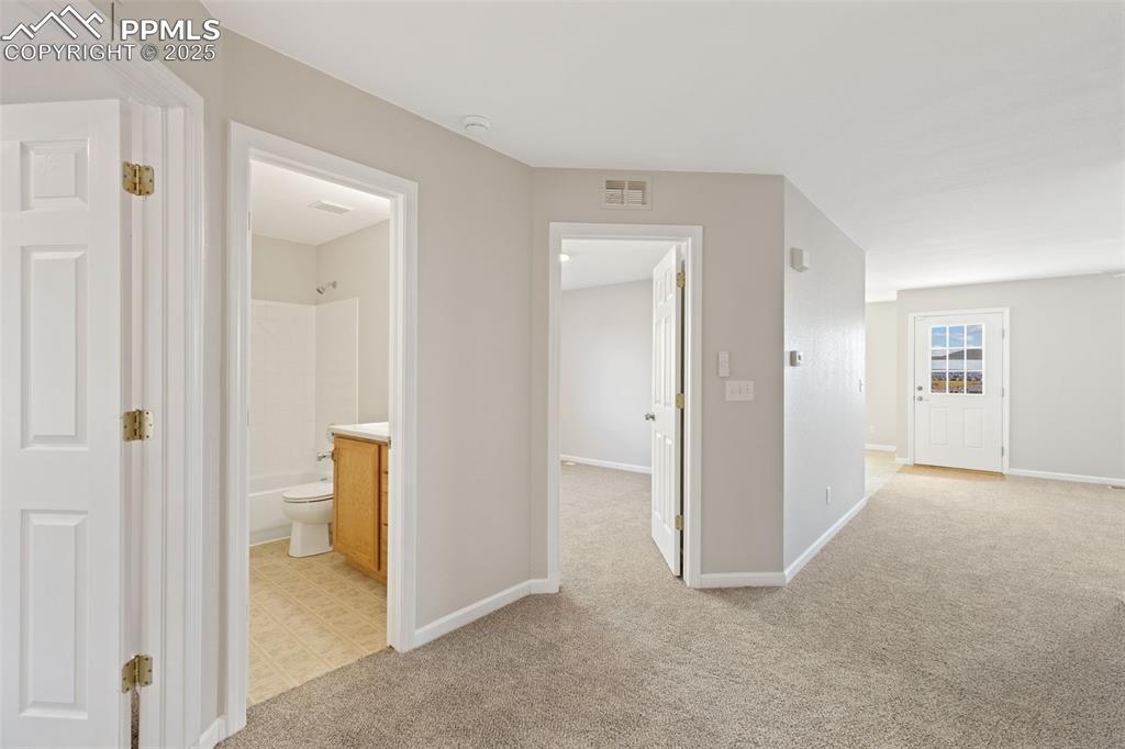 Image 5 of 50: Front entry features two bedrooms and a full bathroom off to the left