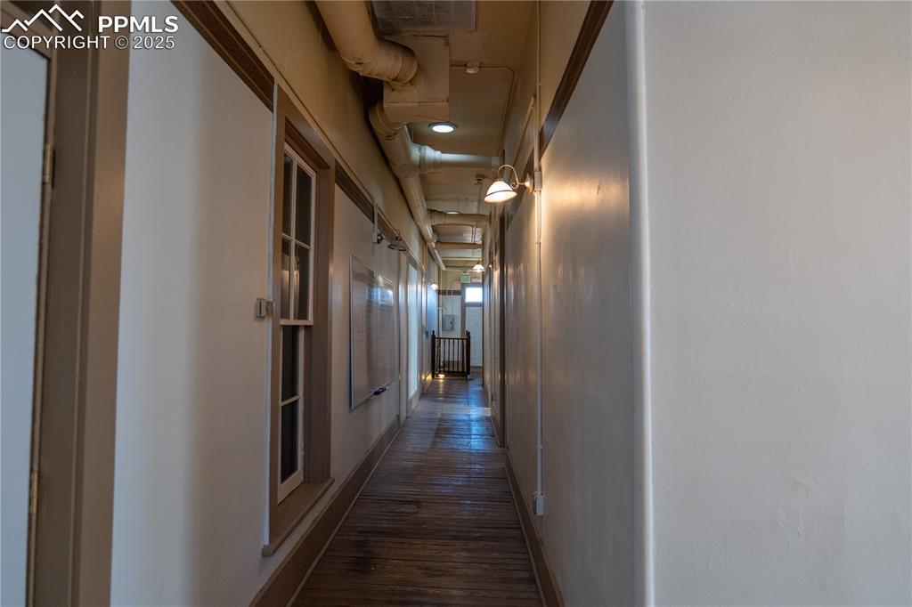 Image 14 of 22: Upper hallway connecting office/rooms on upper level including stairs and e