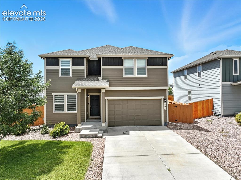 Caption: Contemporary two-story exterior with a two-car garage, concrete driveway, and front lawn