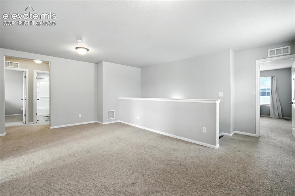 Image 16 of 42: Carpeted floor, neutral wall paint, overhead lighting, white trim, and a pa