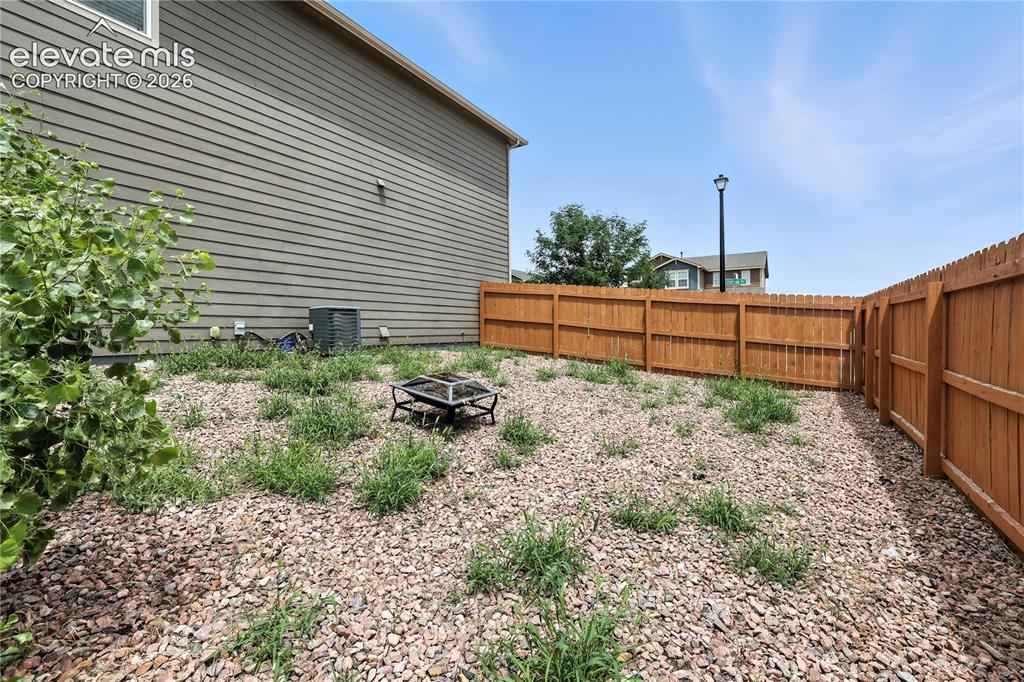 Image 38 of 42: Fenced backyard featuring a gravel surface and privacy fencing