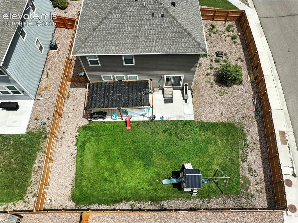 Image 40 of 42: Expansive backyard with a manicured lawn, gravel landscaping, and wood priv
