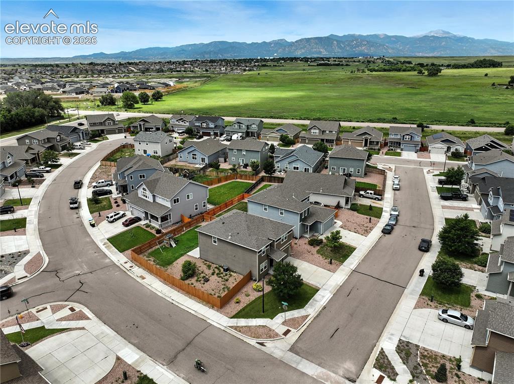 Image 42 of 42: Residential community with varied architectural styles, paved streets, and 