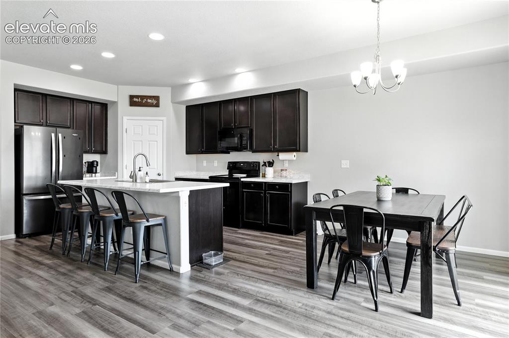 Image 6 of 42: Kitchen featuring dark wood-finish cabinetry, stainless steel appliances, a