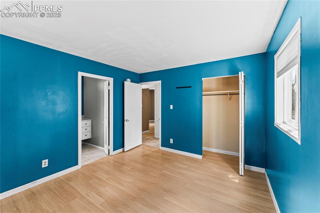 Image 11 of 27: Unfurnished bedroom with a closet and wood finished floors