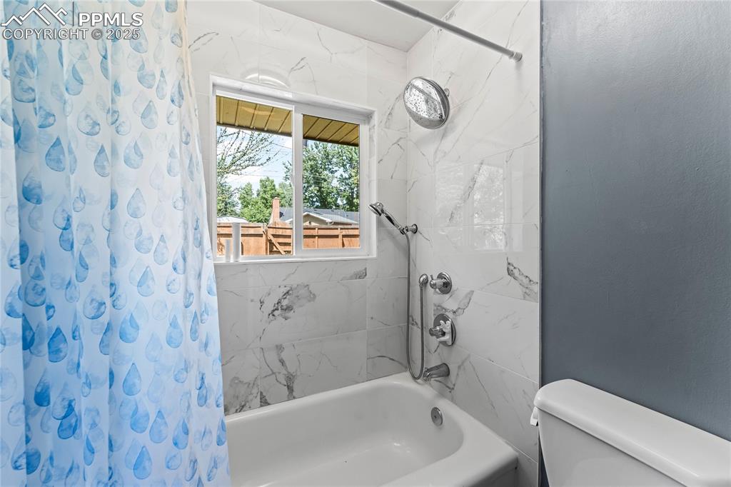Image 13 of 27: Full bath with shower / bathtub combination with curtain and toilet