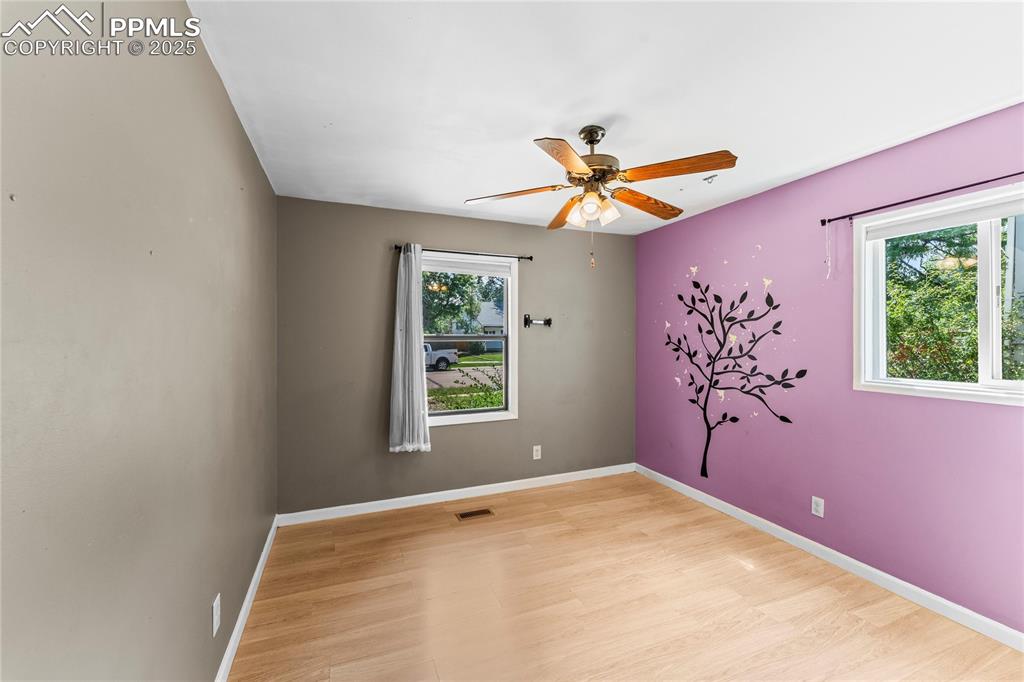 Image 14 of 27: Empty room featuring light wood-style flooring and a ceiling fan