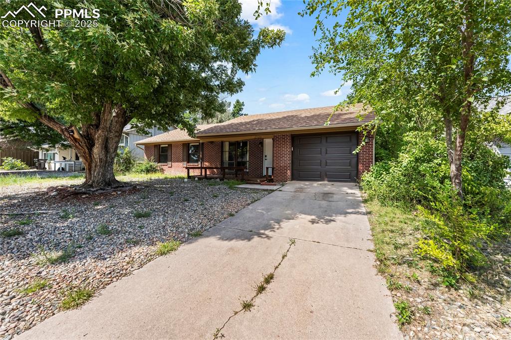 Image 2 of 27: Single story home with concrete driveway, brick siding, an attached garage,