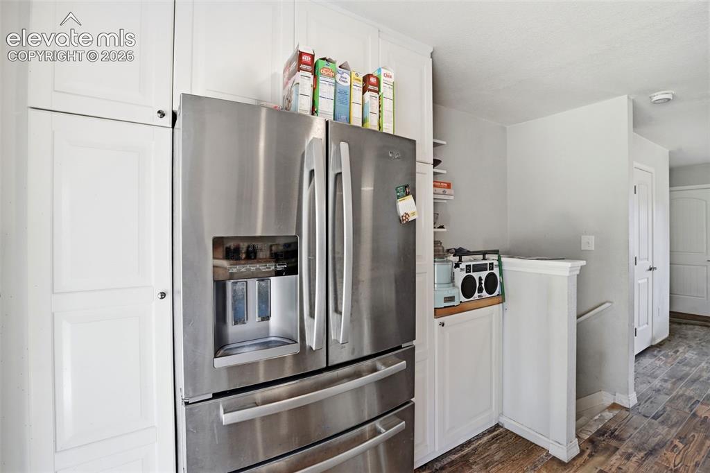 Image 13 of 34: Stainless steel French door refrigerator, white shaker-style cabinetry, woo