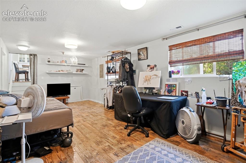 Image 19 of 34: Wood-finish flooring throughout, featuring a window with a woven shade, rec