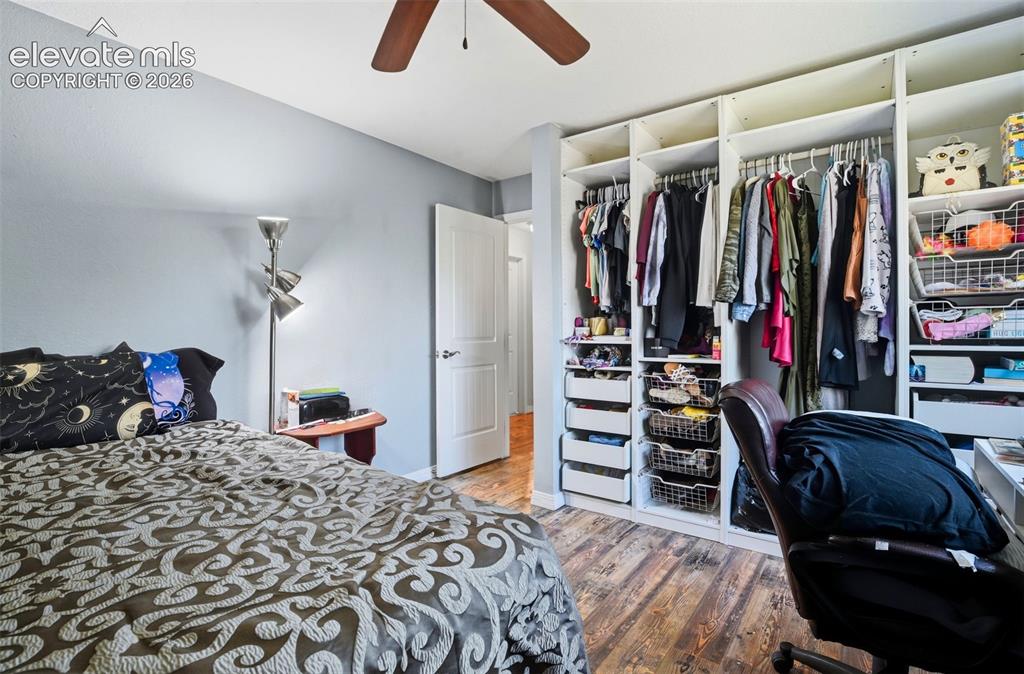 Image 24 of 34: Built-in closet system with shelving and hanging rods, wood-finish flooring
