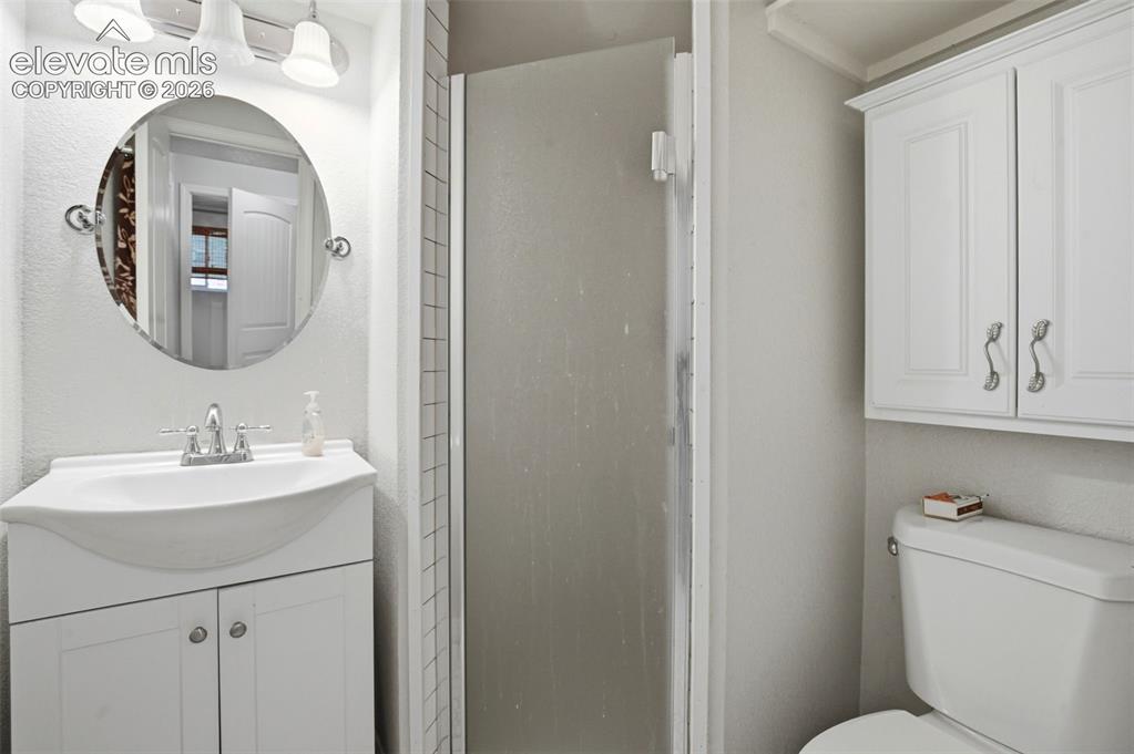 Image 26 of 34: White vanity with an integrated sink, polished chrome faucet, and round mir
