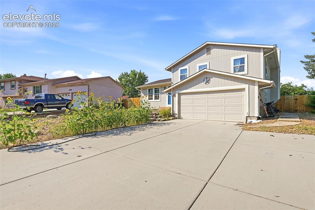 Image 3 of 34: Two-story property with light-colored siding, a two-car garage, and a concr