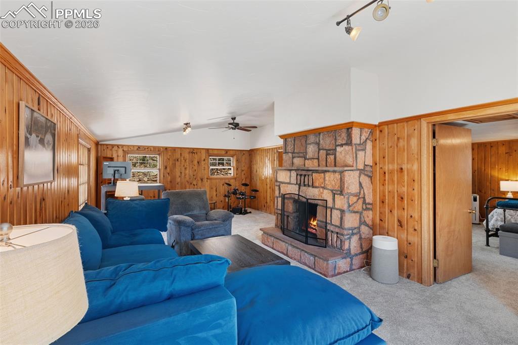 Image 17 of 35: upper level living room with vaulted ceiling & fireplace