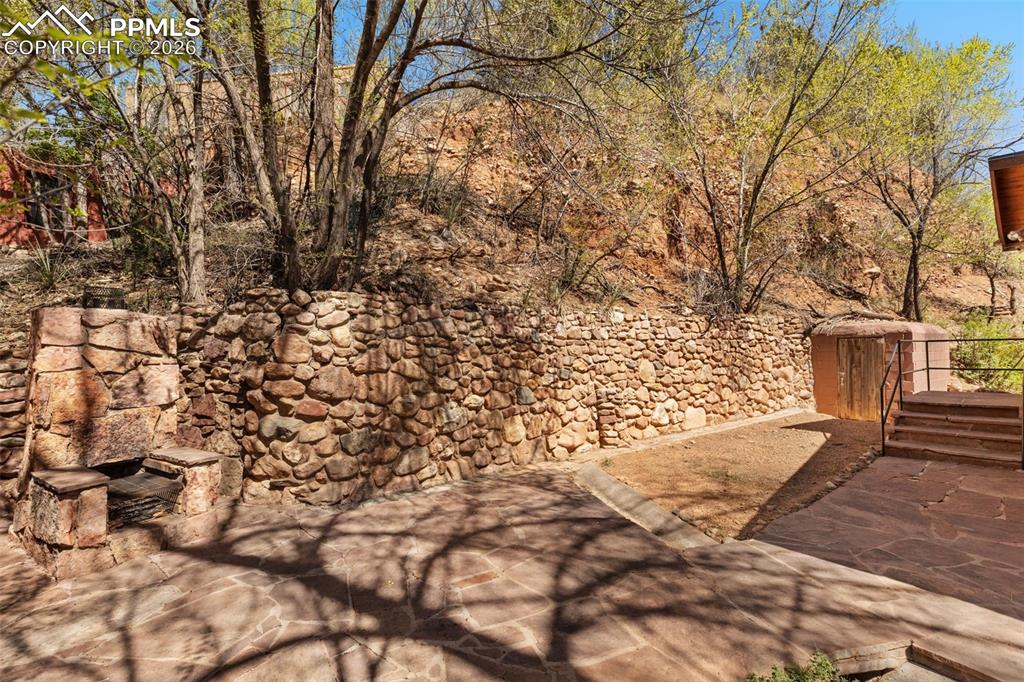Image 4 of 35: stone fireplace/ grill on back patio