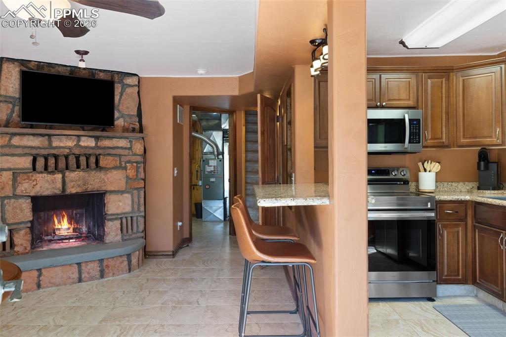 Image 9 of 35: main level fireplace, family room,  adjoining kitchen