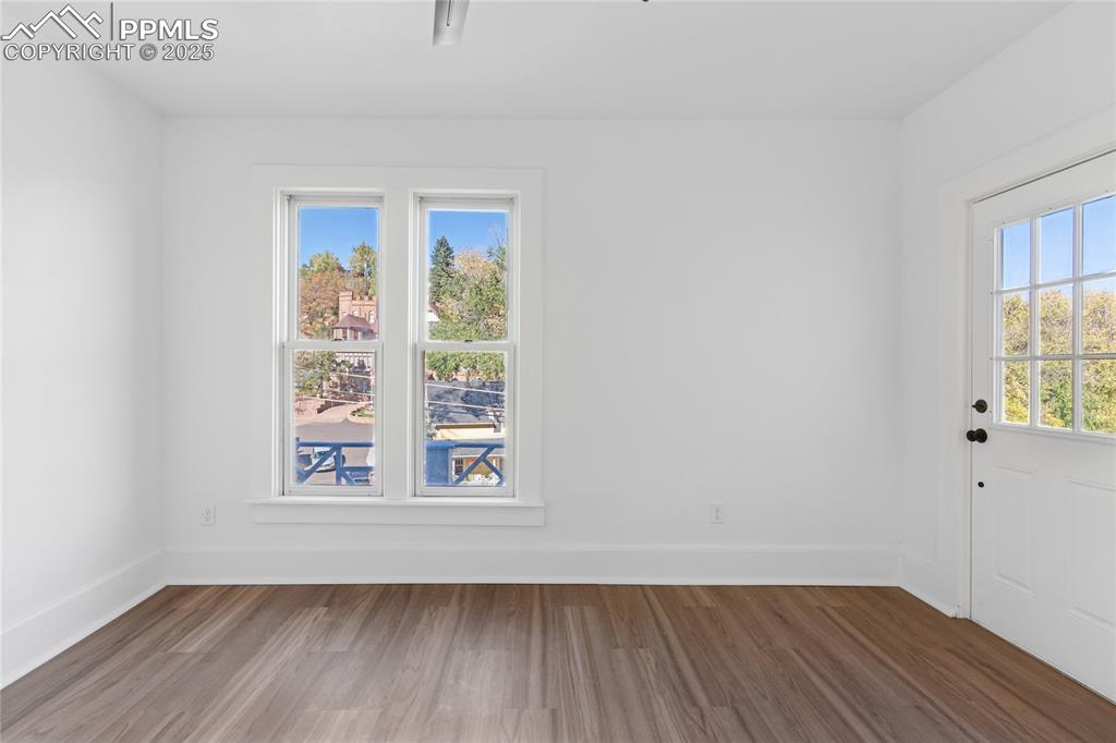 Image 25 of 45: 2nd-floor flat primary bedroom, adjoining shared bath, door to balcony