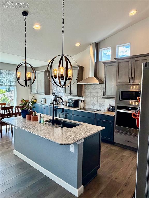 Image 12 of 50: Large island with sink and lots of lighting
