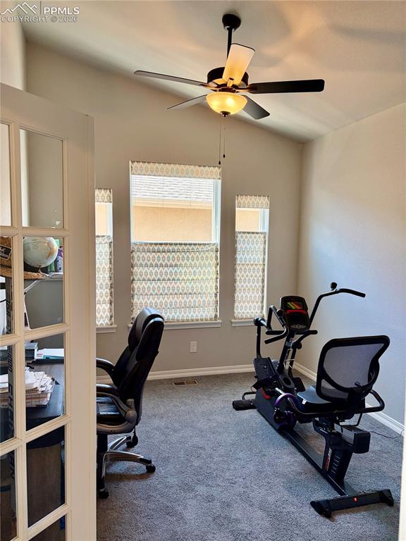 Image 6 of 50: Main level office with ceiling fan and vaulted ceiling