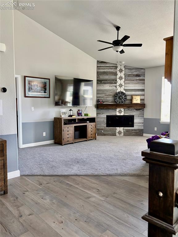 Image 8 of 50: Living room with fireplace, vaulted ceilings and two tone paint