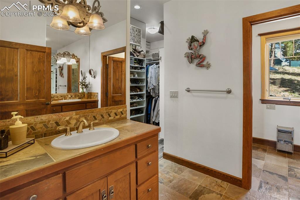 Image 21 of 50: Dual vanities and double closets