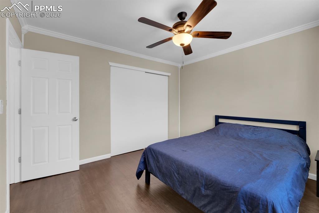 Image 12 of 29: Bedroom 1 with ornamental molding, dark wood finished floors and a ceiling