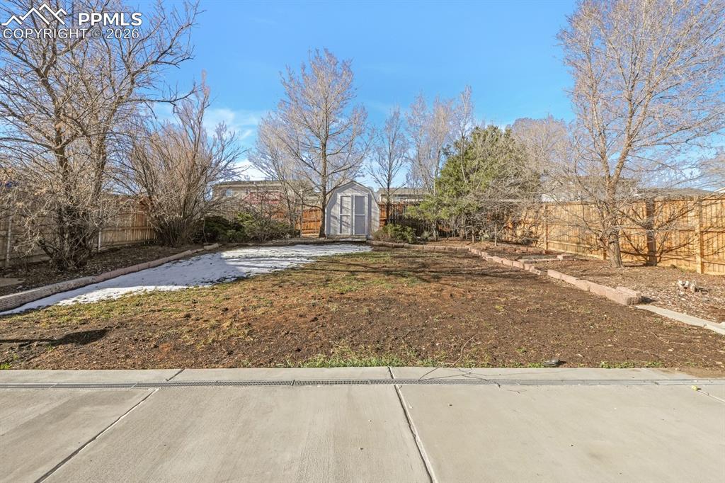 Image 23 of 29: Fenced backyard with a storage shed