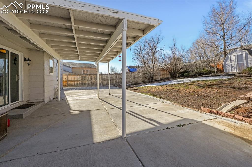 Image 24 of 29: Fenced backyard featuring a patio area and a shed