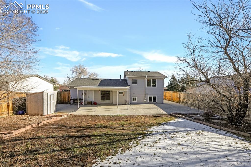 Image 4 of 29: Back of property with a storage shed, a huge partially covered patio, and a