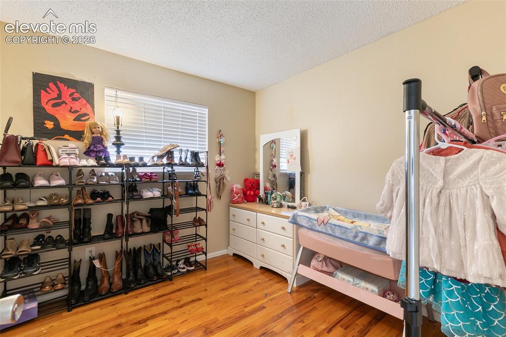 Image 17 of 29: Warm wood-finish flooring complements the neutral wall color