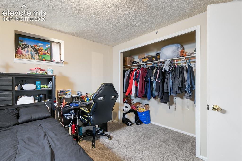 Image 24 of 29: Carpeted bedroom featuring a window, built-in closet with shelving and hang