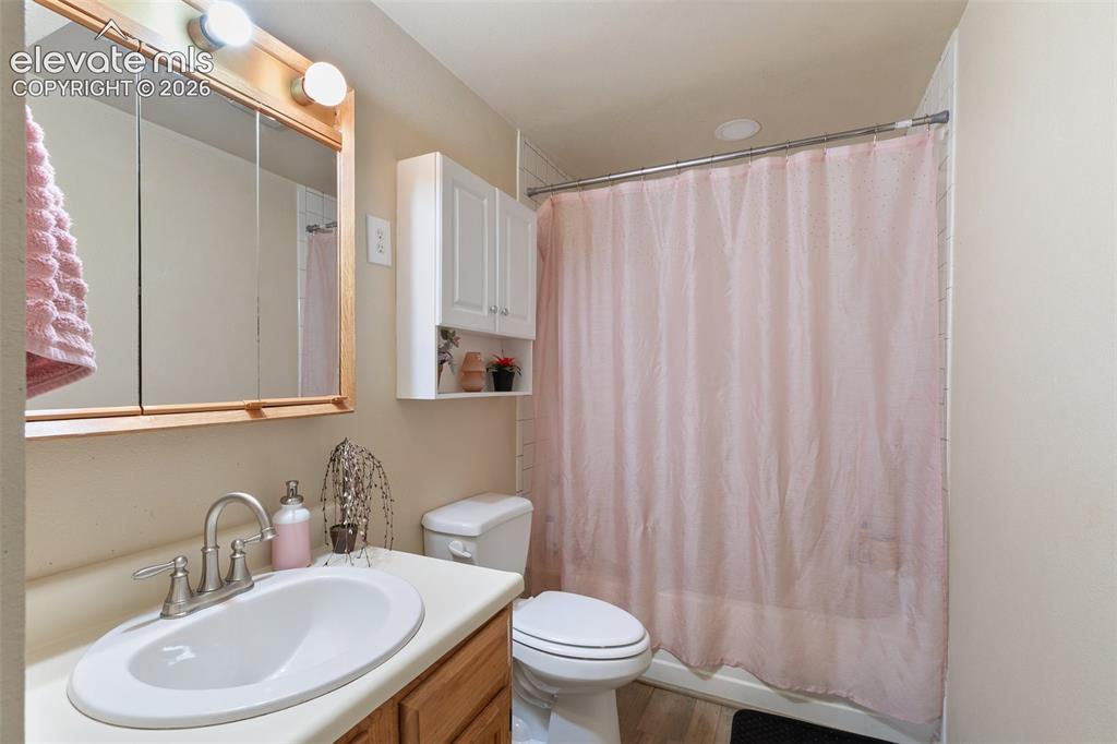 Image 26 of 29: Bathroom featuring a single vanity with wood-finish cabinetry, a built-in s