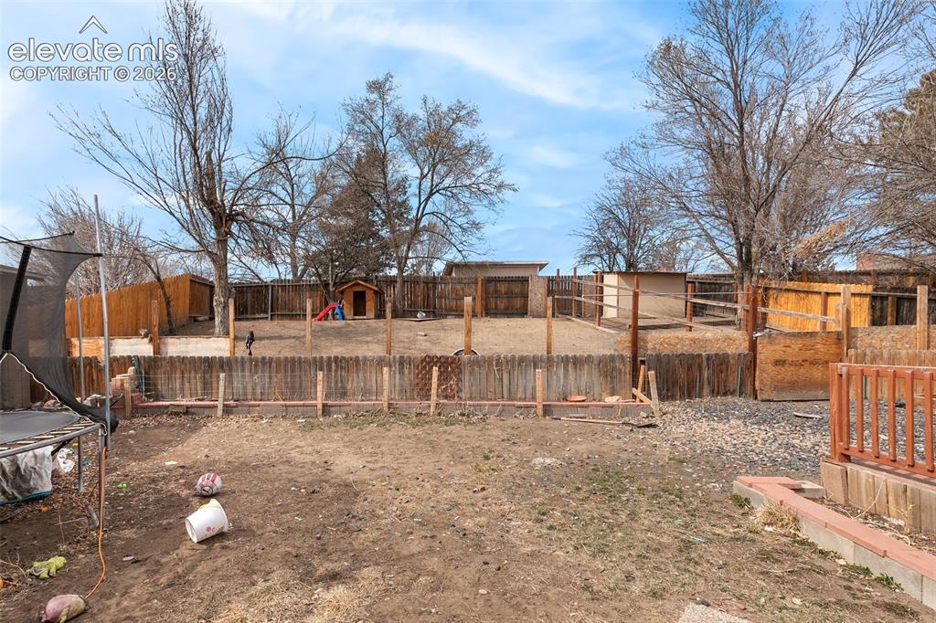 Image 28 of 29: Expansive outdoor space featuring a wood fence perimeter and mature trees