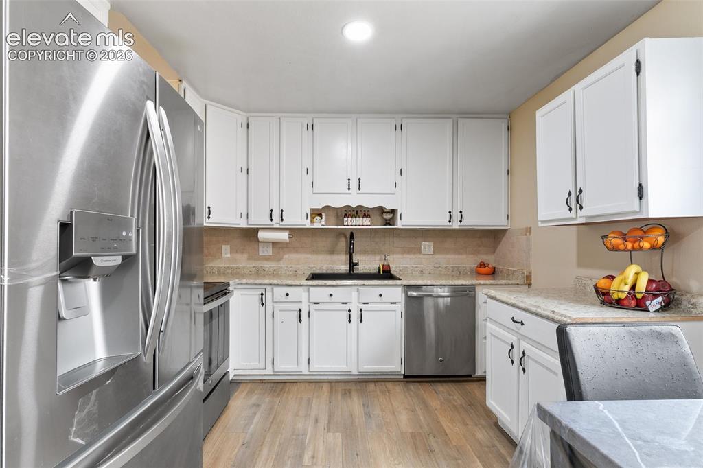 Image 9 of 29: Modern kitchen featuring a stainless steel French door refrigerator, white
