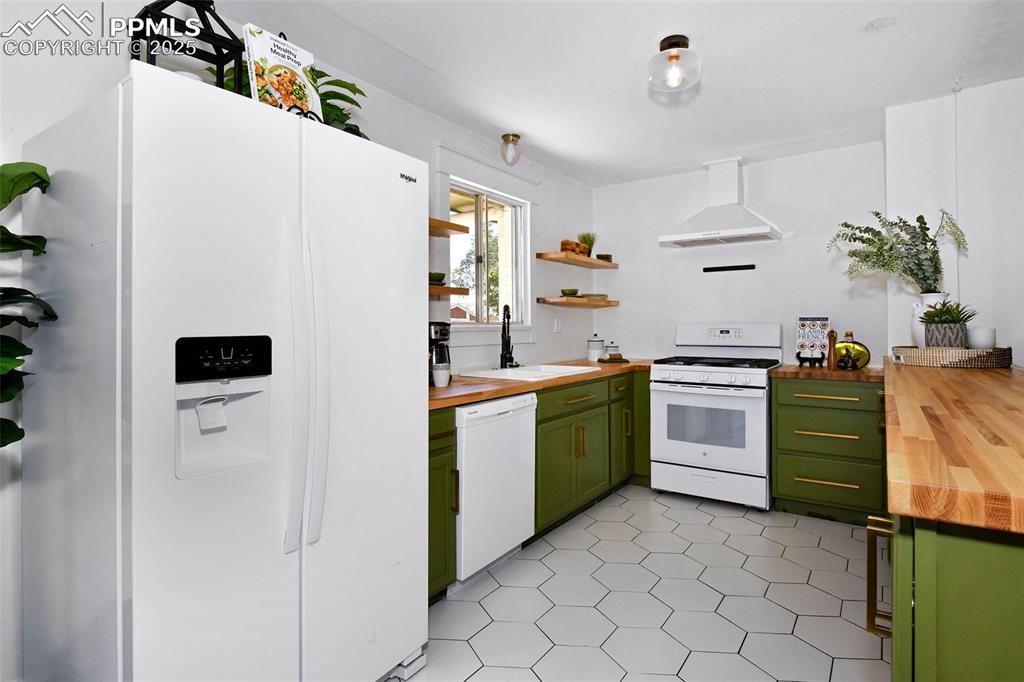 Image 12 of 35: Hexagonal tile floors and butcher-block counters in this updated kitchen!