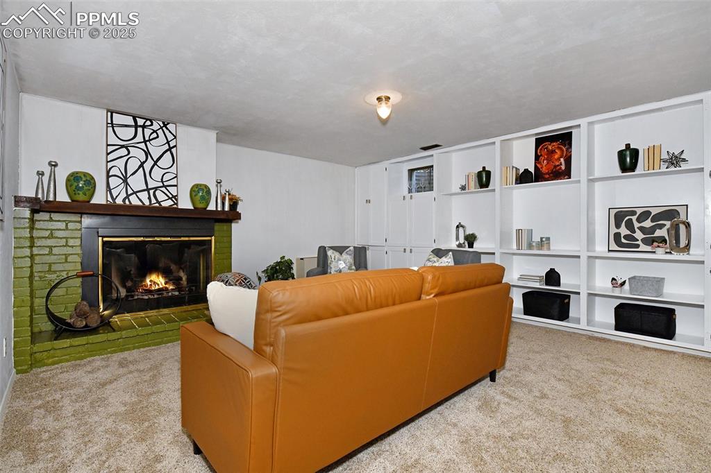 Image 22 of 35: Spacious Family Room features a brick fireplace, built-in bookshelves and a