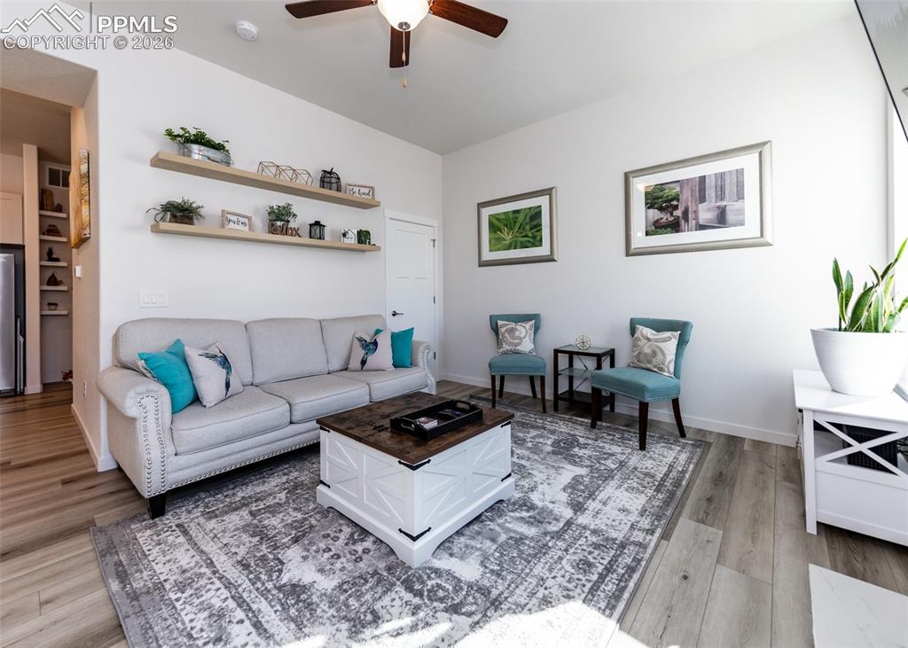 Image 23 of 49: Living area featuring ceiling fan and light wood-style flooring