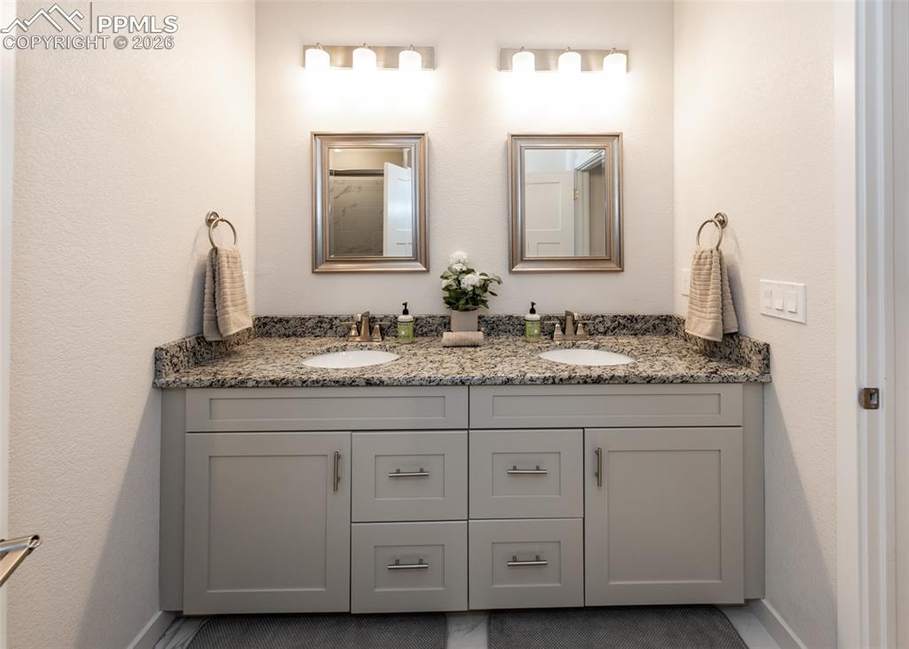 Image 30 of 49: Bathroom featuring double vanity and a textured wall