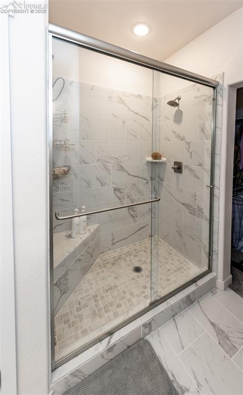 Image 31 of 49: Full bath featuring light marble finish flooring, a shower stall, a spaciou