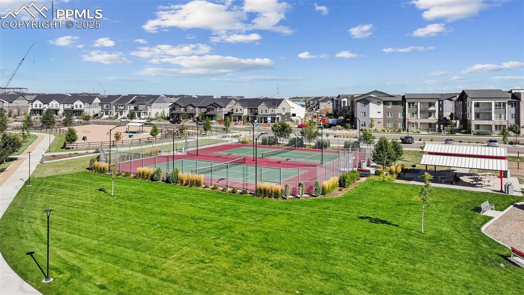 Image 12 of 35: View of tennis court with a residential view