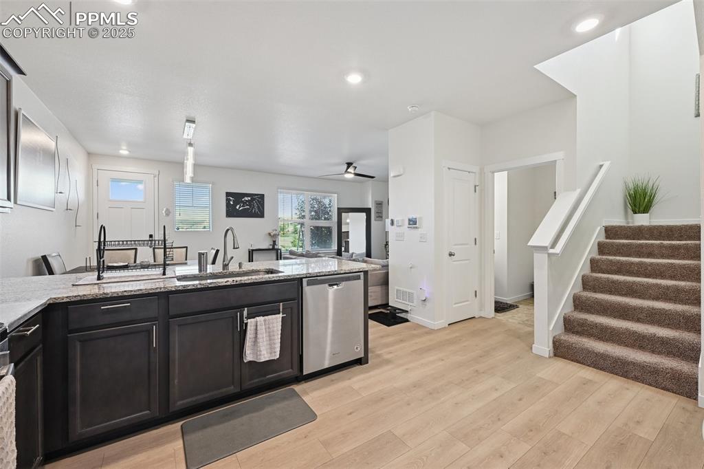 Image 22 of 35: Kitchen featuring dishwasher, light stone counters, recessed lighting, ligh