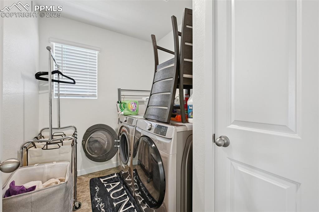Image 29 of 35: Laundry area featuring washing machine and dryer and baseboards