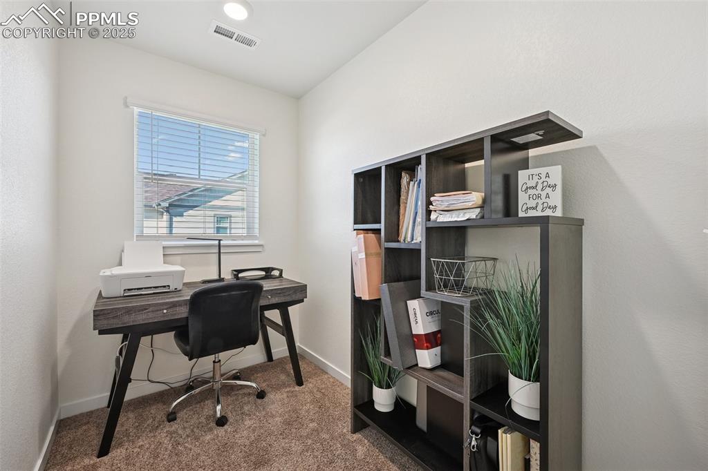 Image 30 of 35: Carpeted home office with baseboards