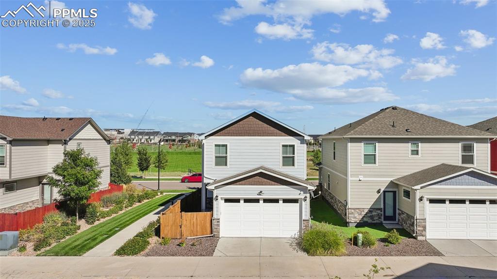 Image 5 of 35: View of front of home featuring driveway, a residential view, stone siding,