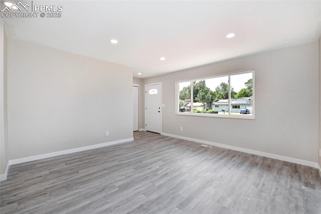 Image 10 of 25: Unfurnished living room with recessed lighting and light wood-style floors