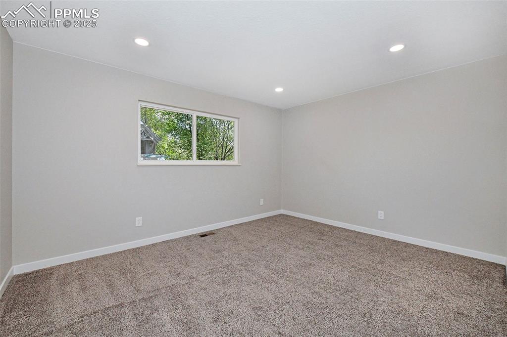 Image 15 of 25: Carpeted spare room with recessed lighting